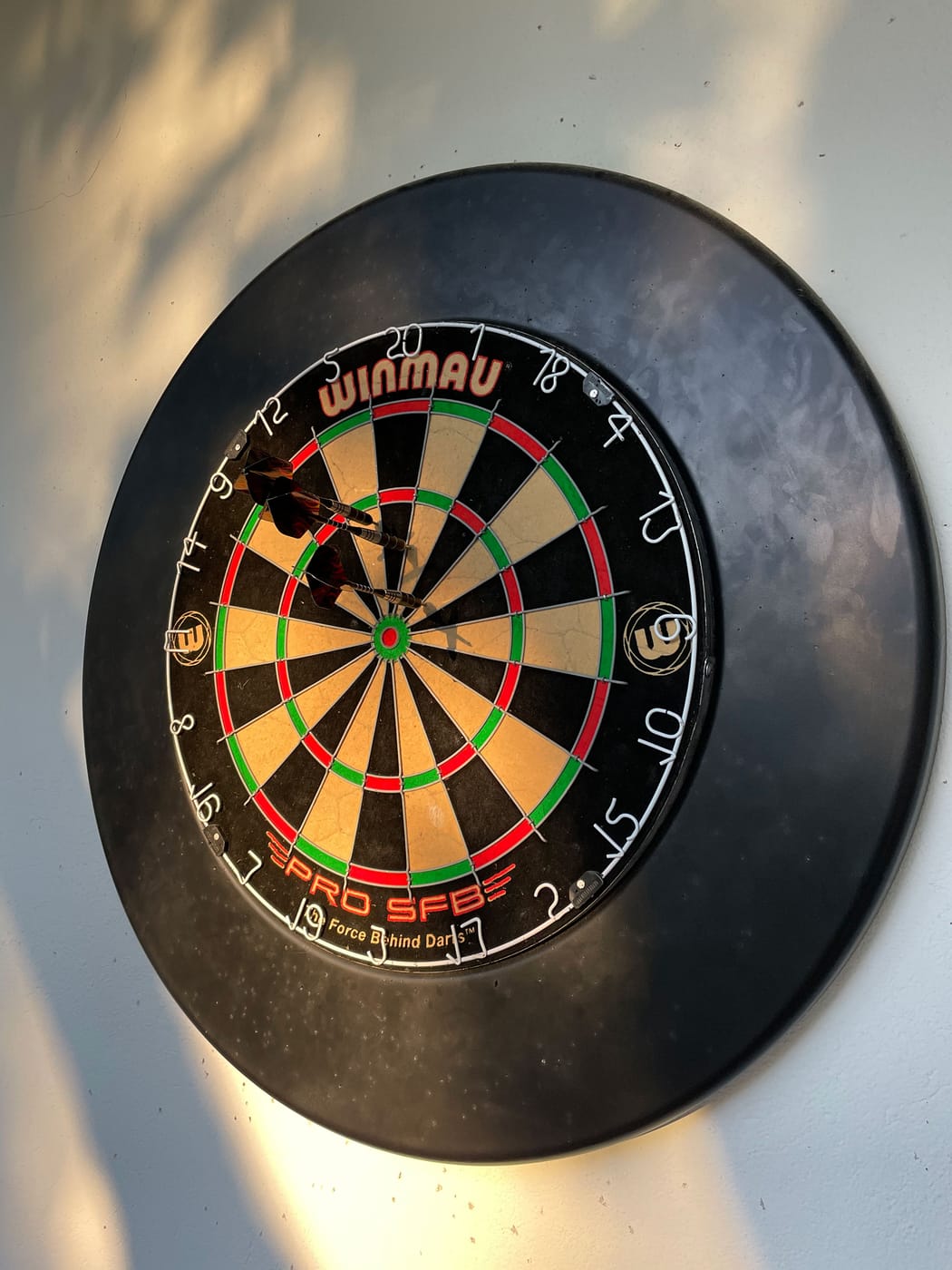 Trois fléchettes plantées dans une cible de jeu au mur lors d'une pause détente de coworking