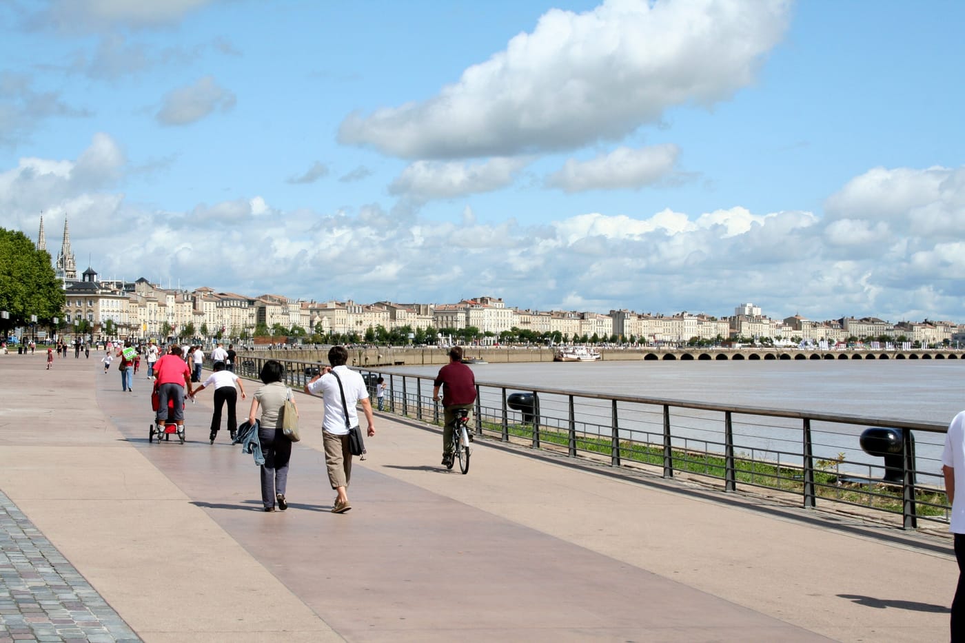 Cycliste et piétons circulant sur les quais de la Garonne à Bordeaux